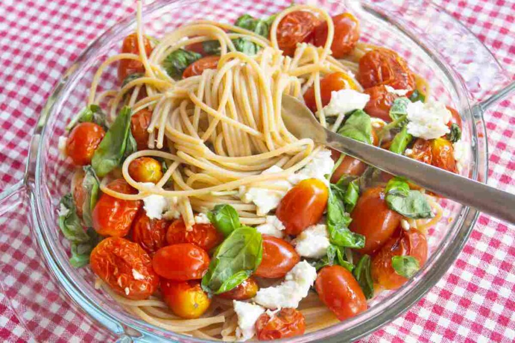 Un piatto di pasta estiva con pomodorini, mozzarella e basilico