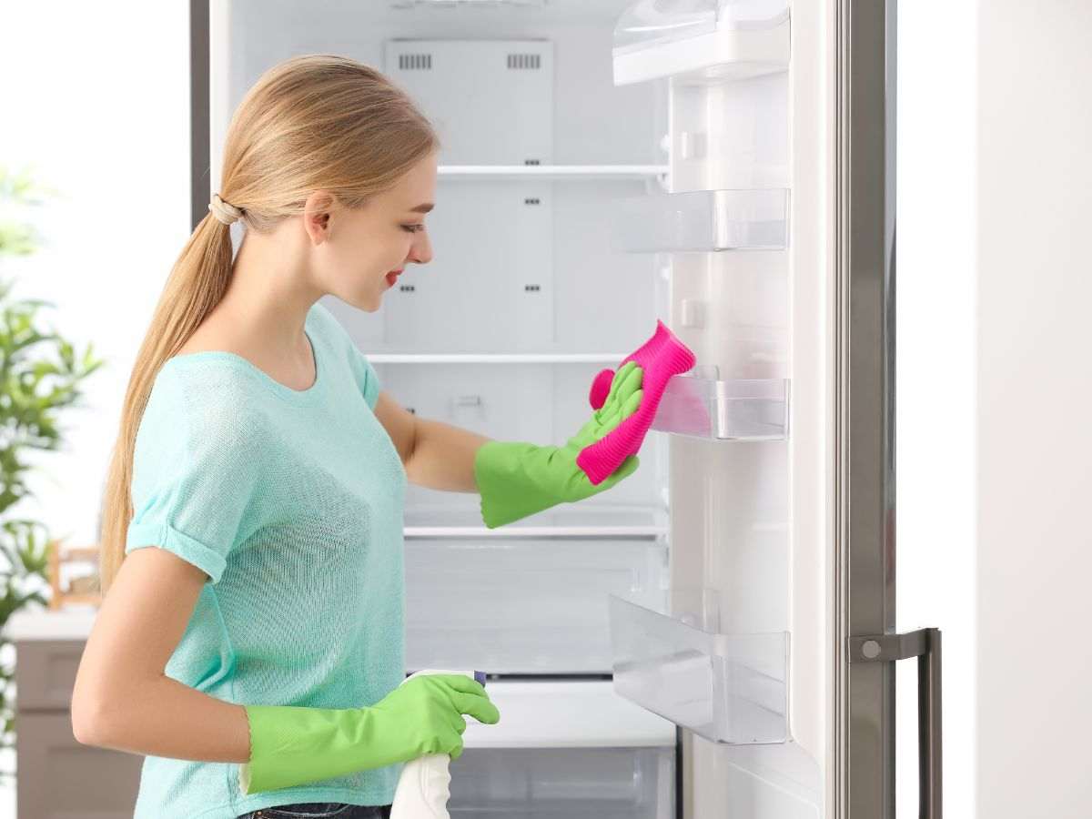 donna pulisce scomparti del frigo